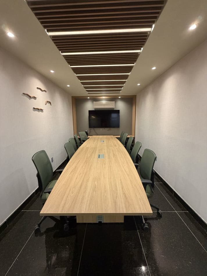 Sala de reunião Ação com mesa longa de madeira